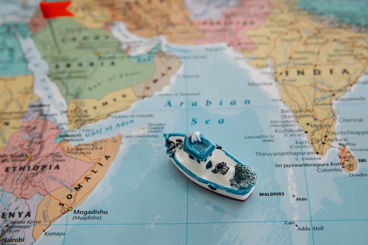 ours-journey Close-up of a toy boat placed on the Arabian Sea section of a world map depicting regions around India.